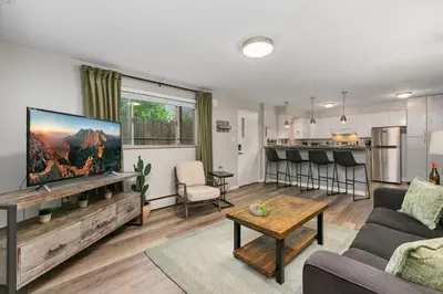 a living room with a couch and a tv at Stunning Downtown Condo - 5 min walk to Old Town! in Fort Collins