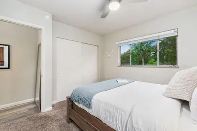 a white bedroom with a bed and a window at Stylish Condo in the Heart of Old Town in Fort Collins