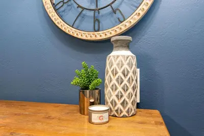 a vase sitting on a table in front of a mirror at Stylish Condo in the Heart of Old Town in Fort Collins