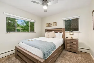 a bedroom with a bed and two windows at Stylish Condo in the Heart of Old Town in Fort Collins