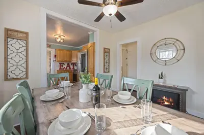 a dining room with a table and chairs and a fireplace at Newly Renovated in the Heart of Historic Loveland in Loveland