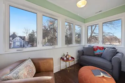 a living room with windows and a couch and a table at Newly Renovated in the Heart of Historic Loveland in Loveland