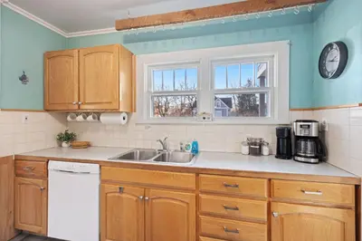 a kitchen with wooden cabinets and a sink at Newly Renovated in the Heart of Historic Loveland in Loveland