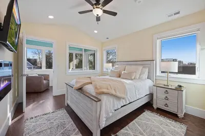 a bedroom with a bed and a tv and windows at Newly Renovated in the Heart of Historic Loveland in Loveland