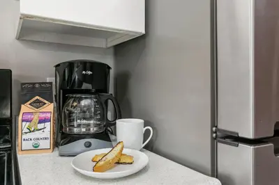 a plate of french fries on a counter next to a coffee maker at Old Town Condo by Library Park Walk Everywhere! in Fort Collins