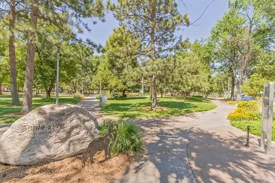 a statue of a goat next to a rock in a park at Old Town Condo by Library Park Walk Everywhere! in Fort Collins