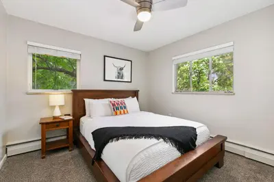 a bedroom with a bed and two windows at Old Town Condo by Library Park Walk Everywhere! in Fort Collins