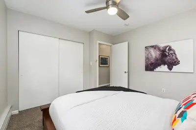 a bedroom with a bed and a ceiling fan at Old Town Condo by Library Park Walk Everywhere! in Fort Collins