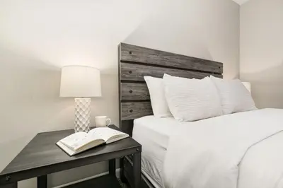 a bedroom with a bed and a table with a book at Old Town Condo by Library Park Walk Everywhere! in Fort Collins