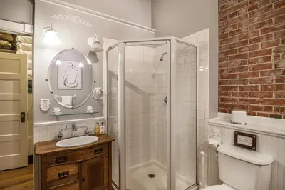 a bathroom with a shower and a toilet and a sink at Elegant Loft-Style Retreat in Old Firehouse Alley in Fort Collins