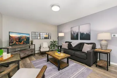 a living room with a couch and a tv at Breathtaking Condo in the Heart of Old Town in Fort Collins