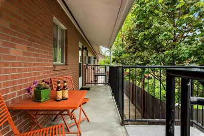 a patio with a wooden table and chairs on a balcony at Breathtaking Condo in the Heart of Old Town in Fort Collins