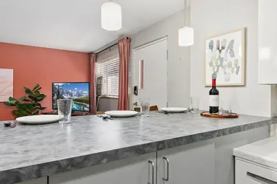 a kitchen with a counter with a bottle of wine at Hip & Urban Condo near the Heart of Old Town in Fort Collins