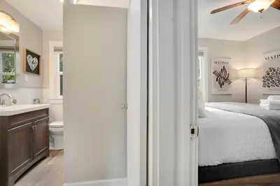 a bedroom with a bed and a bathroom with a sink at Charming Old Town Bungalow with Free Cruiser Bikes in Fort Collins
