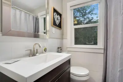 a bathroom with a sink and a toilet and a window at Charming Old Town Bungalow with Free Cruiser Bikes in Fort Collins