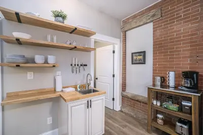 a kitchen with a sink and a brick wall at Gorgeous Guest Suite - Walk to Old Town and CSU! in Fort Collins