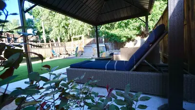 a patio with a chair and an umbrella at Gorgeous Guest Suite - Walk to Old Town and CSU! in Fort Collins