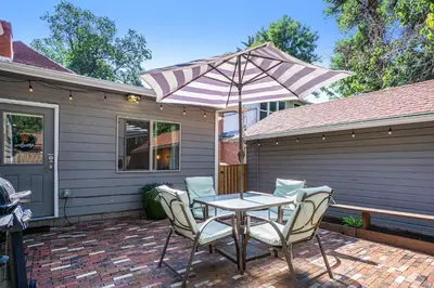 a table and chairs with an umbrella on a patio at Gorgeous Guest Suite - Walk to Old Town and CSU! in Fort Collins