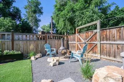 a backyard with two chairs and a fence at Gorgeous Guest Suite - Walk to Old Town and CSU! in Fort Collins