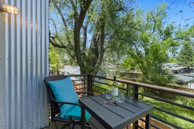 a table and chairs on a balcony with a tree at Industrial Old Town Bungalow with Free Cruiser Bikes in Fort Collins