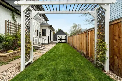 a backyard with a white pergola and green lawn at Lola House! Cozy Comfort, Prime Old Town Location in Fort Collins