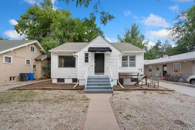 a white house with stairs leading to the front door at Beautiful Bungalow Next to CSU, Free Cruiser Bikes in Fort Collins