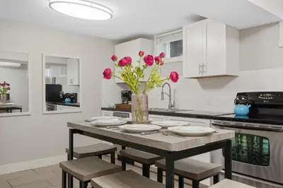 a kitchen with a table with pink flowers in a vase at Charming Bungalow Next to CSU - Free Cruiser Bikes in Fort Collins