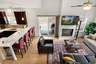 a living room with a kitchen and a living room with a couch at Modern Townhome Steps from the Brewery District! in Fort Collins