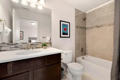 a bathroom with a sink and a toilet and a mirror at Modern Townhome Steps from the Brewery District! in Fort Collins