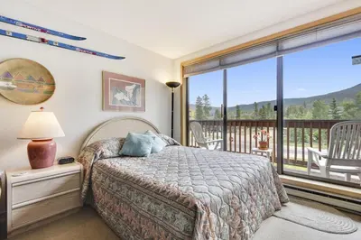 a bedroom with a bed and a balcony at Cedar Lodge 221 condo in Frisco