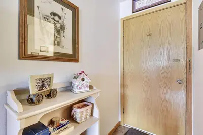 a hallway with a wooden door and a shelf at Cedar Lodge 221 condo in Frisco