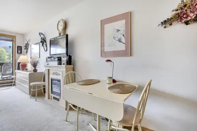 a dining room with a white table and chairs at Cedar Lodge 221 condo in Frisco