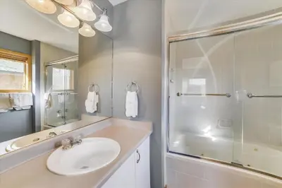 a white bathroom with a sink and a shower at Lagoon 736D townhouse in Frisco