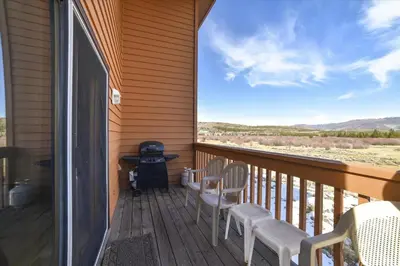a porch with chairs and a grill and a view at Lagoon 736D townhouse in Frisco