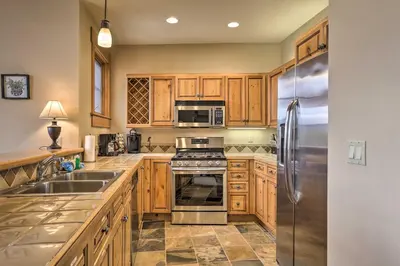 a kitchen with wooden cabinets and a stainless steel refrigerator at 3 Mi to Keystone Resort Condo with Mountain View in Keystone