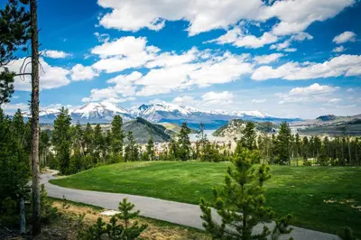 a golf course with snow covered mountains in the background at 3 Mi to Keystone Resort Condo with Mountain View in Keystone