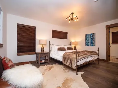 a bedroom with a bed and a table with a lamp at Rocky Mountain Escape - Steps to Lake Estes, Jacuzzi, Close to Downtown Estes in Estes Park