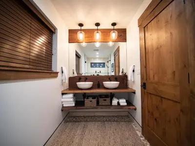 a bathroom with two sinks and a mirror at Rocky Mountain Escape - Steps to Lake Estes, Jacuzzi, Close to Downtown Estes in Estes Park