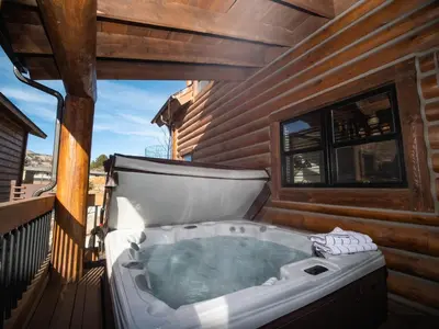 a hot tub on the deck of a house at Estes Escape – Jacuzzi, Indoor/Outdoor Fireplace and BBQ Grill in Estes Park