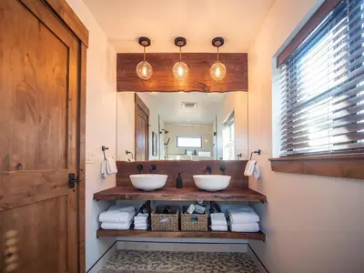 a bathroom with two sinks and a mirror at Lake Estes Getaway – Close to Downtown, Indoor/Outdoor Fireplace and Jacuzzi in Estes Park