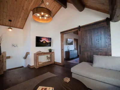 a living room with a couch and a wooden ceiling at Lake Estes Getaway – Close to Downtown, Indoor/Outdoor Fireplace and Jacuzzi in Estes Park
