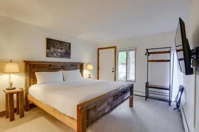 a bedroom with a bed and a flat screen tv at Walk to Ski Shuttle Cozy Mountain Meadows Condo in Frisco