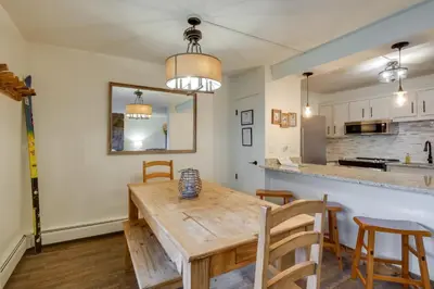 a kitchen and dining room with a wooden table and chairs at Walk to Ski Shuttle Cozy Mountain Meadows Condo in Frisco
