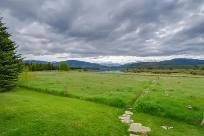 a green field with rocks in the middle of it at Walk to Ski Shuttle Cozy Mountain Meadows Condo in Frisco