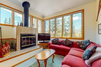 a living room with a red couch and a fireplace at Red Fox in Dillon