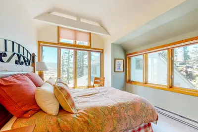 a bedroom with a bed with pillows and windows at Red Fox in Dillon