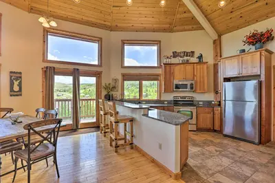 a kitchen with wooden cabinets and a table and chairs at 2 Mi to Granby Ranch Granby Home with Hot Tub! in Granby