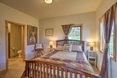 a bedroom with a wooden bed and a window at 2 Mi to Granby Ranch Granby Home with Hot Tub! in Granby