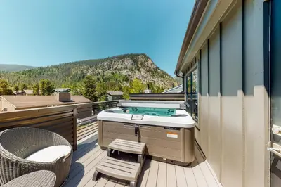 a balcony with a hot tub and a table and chairs at Woodhaven Hideaway in Frisco