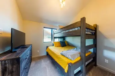 a bedroom with a bunk bed and a television at Woodhaven Hideaway in Frisco